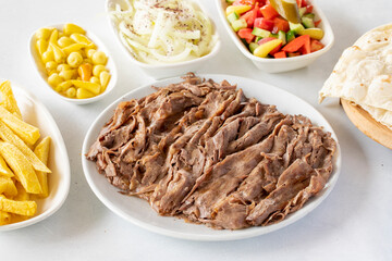 Doner kebab on a white background. Traditional Turkish cuisine flavor meat doner. With lavash bread, french fries, salad and onions on the side