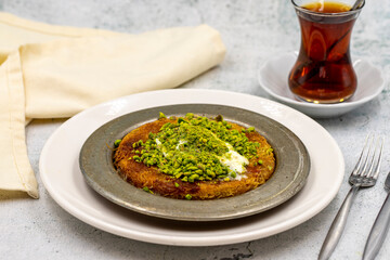 Pistachio kunefe on stone background. Traditional Turkish cuisine flavor