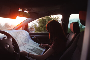Young girl looking a map during a road trip.
