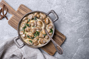 Frying pan of mushrooms in cream sauce with spinach