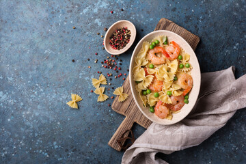 Bowl of italian farfalle pasta with shrimps and green peas