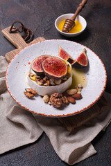 Brie or camembert cheese with fresh figs, nuts and honey