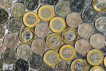Background from Kazakhstani coins with a face value of 50 and 100 tenge, top view