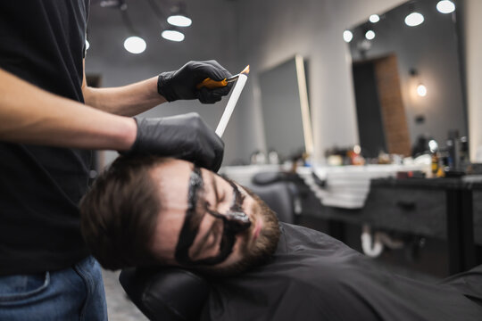 Man in a beauty salon is removing earwax using candles. Male enjoying a spa treatment