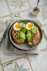Sandwiches with wheat bread, cream cheese, canned tuna, fresh cucumber, boiled eggs and pea microgreens. A light, nutritious snack for a healthy lunch