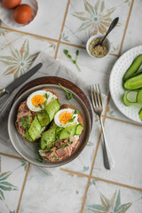 Sandwiches with wheat bread, cream cheese, canned tuna, fresh cucumber, boiled eggs and pea microgreens. A light, nutritious snack for a healthy lunch