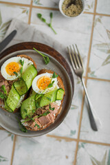 Sandwiches with wheat bread, cream cheese, canned tuna, fresh cucumber, boiled eggs and pea microgreens. A light, nutritious snack for a healthy lunch