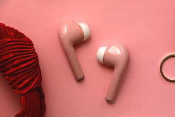 Pink bluetooth earphones, red hairband, pearl hair clips, gold earrings and ring, pink blush and...