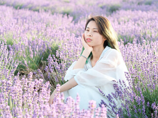 Beautiful Asian young woman model in spring or summer lavender field, Chinese girl enjoy her time in purple flower field in sunny afternoon.