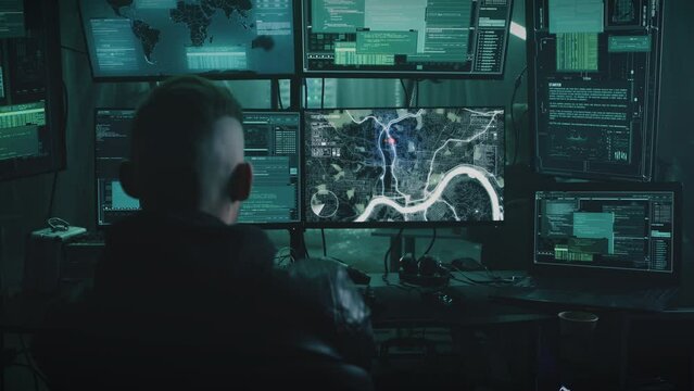 Zoom in view of anonymous man using illegal software on computer while spying on victims with associates. Conducts surveillance by determining the location and geolocation online virtual map