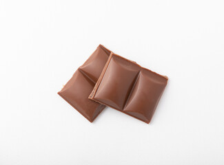 Cubes of delicious milk chocolate isolated on white background.
