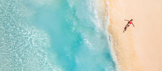 Aerial view of a woman relaxing on tropical beach Maldives islands. Vacation adventure aerial beach...