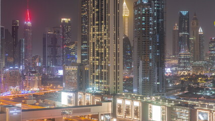 Fototapeta premium Row of the tall buildings around Sheikh Zayed Road and DIFC district aerial night timelapse in Dubai