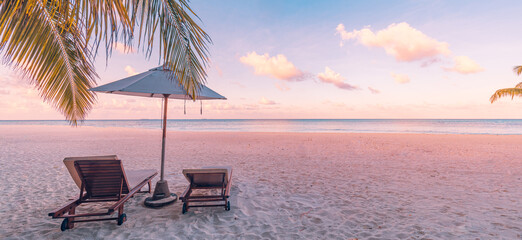 Panoramic tropical sunset scenery, two sun beds, loungers, umbrella under palm tree. White sand,...