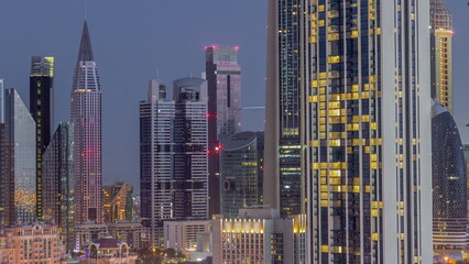 Row of the tall buildings around Sheikh Zayed Road and DIFC district aerial night to day timelapse in Dubai
