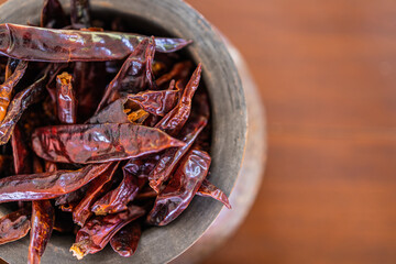 Top view closeup dry red chili peppers on brown wooden table. Dried red chili peppers closeup, traditional food ingredients. Macro raw