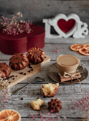 Homemade festive breakfast. Hot cappuccino coffee in a transparent mug and homemade and homemade muffin on a wooden table