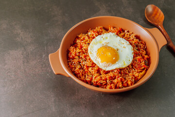 Korean food kimchi fried rice dish with fried egg on white plate