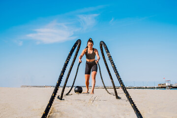 Sportive girl training on the beach - Fitness woman with sportswear doing functional training...