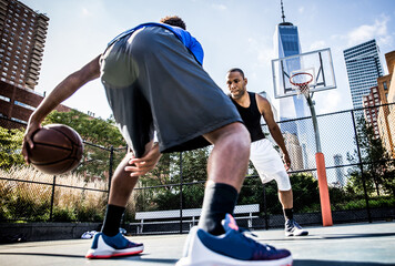 Two basketball players playing hard on the court. Street basketball challenge in New york. Concept...