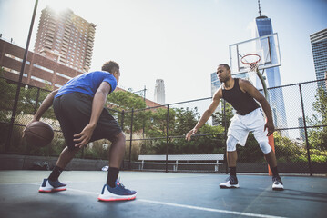 Two basketball players playing hard on the court. Street basketball challenge in New york. Concept...