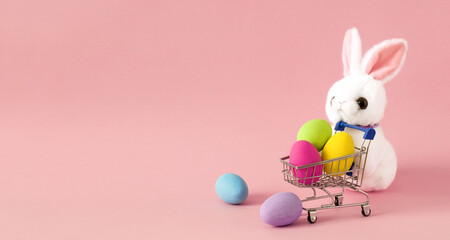 happy easter sale  banner design with cute rabbit toy  small shopping cart with eggs copy space