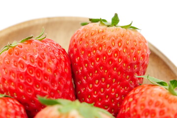 A space with a pure white background, lots of strawberries served in a wooden bowl.