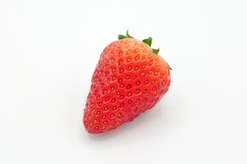 A single bright red strawberry placed in a space with a pure white background.