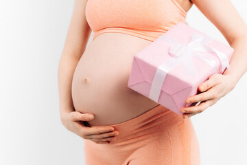 Cropped image of an attractive pregnant woman holding a gift box in her hands on a white background