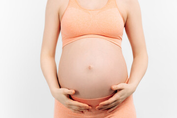 pregnant woman holds her hands on her stomach on a white background. Pregnancy, motherhood