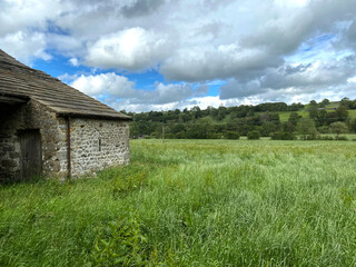 Yorkshire Dales rural scene, with an old stone barn, long grass, and distant hills near, Malham, Skipton, UK