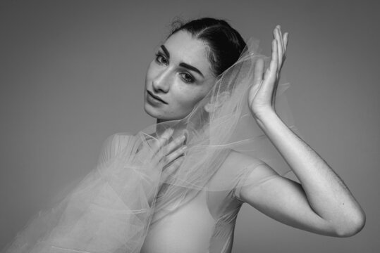 Black and white photo, close-up portrait of a ballerina. Young elegant ballet dancer, dressed in professional clothes, emotional, low key, selective focus. The beauty of classical ballet