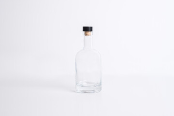 Empty transparent glass bottle with cork screw for drinks and beverage alcohol in blank white isolated background