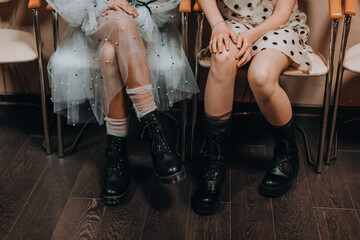 Children's figures in puffy dresses and black boots. Fashion shot