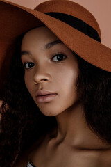 Beauty portrait of sensual young female in hat. Clean skin. Healthy care. Portrait of beautiful african american in hat isolated. Studio shoot. Portrait of beauty model with natural nude make up