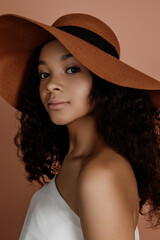 Portrait of sensual young female in hat. Clean skin. Healthy care. Portrait of beautiful african american in hat isolated. Studio shoot. Portrait of beauty model with natural nude make up