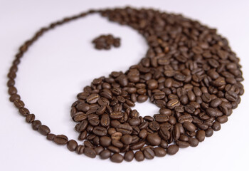 yin yang sign made by coffee beans on white background