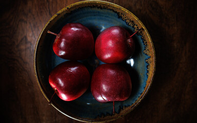 4 red apples in clay bowl