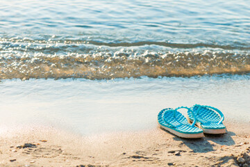 Blue flip flops on sand beach. Summer vacation concept
