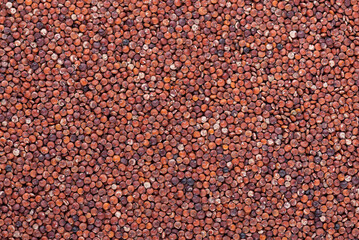 Red quinoa seeds background. Pile of raw kinwa. Top view.