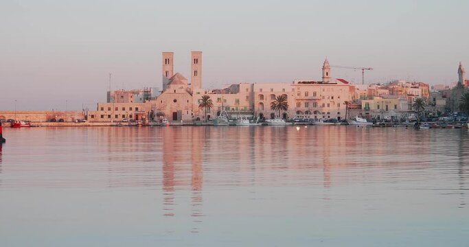 Panoramic view 4K video of Molfetta waterfront with the Old Cathedral San Corrado (Duomo Vecchio),port with ships and yachtsand the Molfetta city sunset. Apulia ,Italy