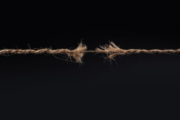 Frayed rope ready to break isolated on black background - obrazy, fototapety, plakaty