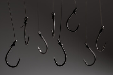 Fishing hooks hanging on a fishing line on a grey background