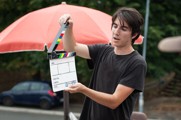 Man holding a clapperboard in front of the camera