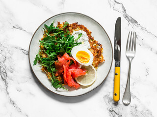 Potato la with egg, arugula, salmon and greek yogurt house on a light background, top view. Delicious food for breakfast