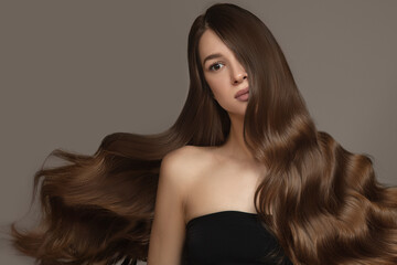Naklejka premium Portrait of a beautiful brunette woman with long wavy hair. Copycpase