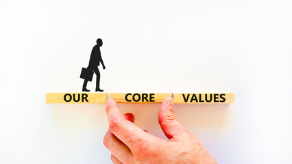 Our core values symbol. Concept words Our core values on wooden blocks on a beautiful white table white background. Businessman hand. Business value and our core values concept. Copy space.