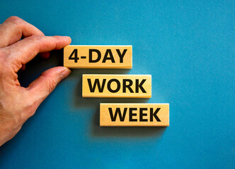 4-day work week symbol. Concept words 4-day work week on wooden blocks on beautiful blue table blue background. Businessman hand. Copy space. Business and 4-day work week and short workweek concept.