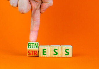Fitness or stress symbol. Doctor turns the wooden cube and changes the word Stress to Fitness. Beautiful orange table orange background. Medical, psychological, fitness or stress concept. Copy space.