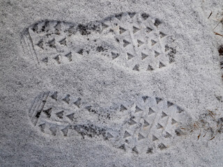 Two prints of running shoes in fresh snow. Two footprints i